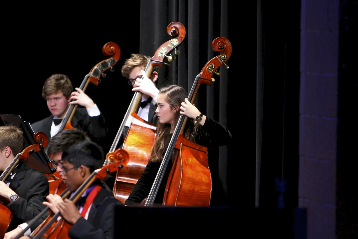 Tu plays with the bass section at a Symphony Orchestra concert.