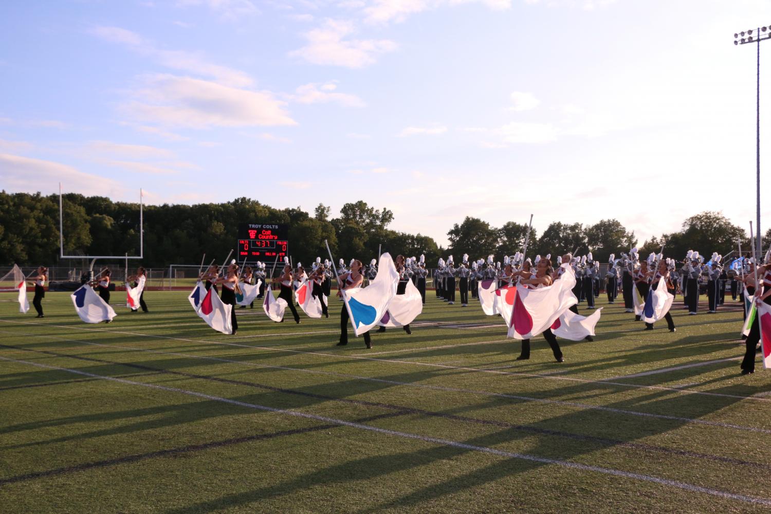 Color guard performs using flags with different colored hearts.