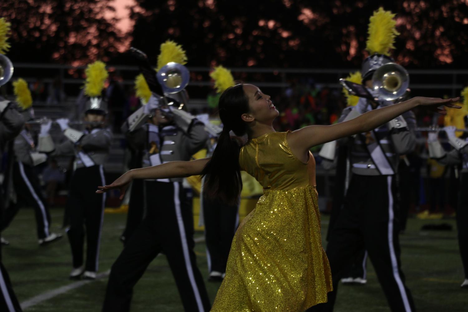 Posing mid-routine, junior Sara Huang performs with color guard.