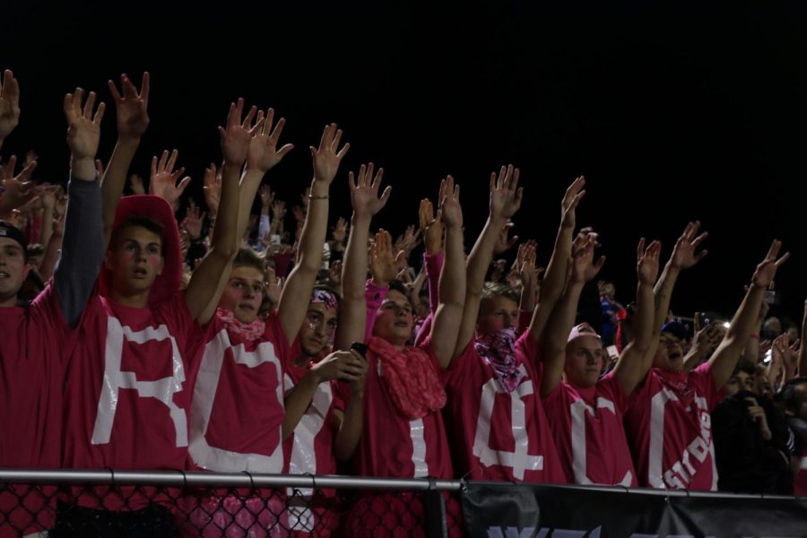 The TC Line raises their arms in support of the football team,