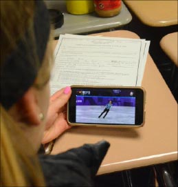 Sophomore Shannon Murphy watches American Adam Rippon in the freestyle portion on her phone.