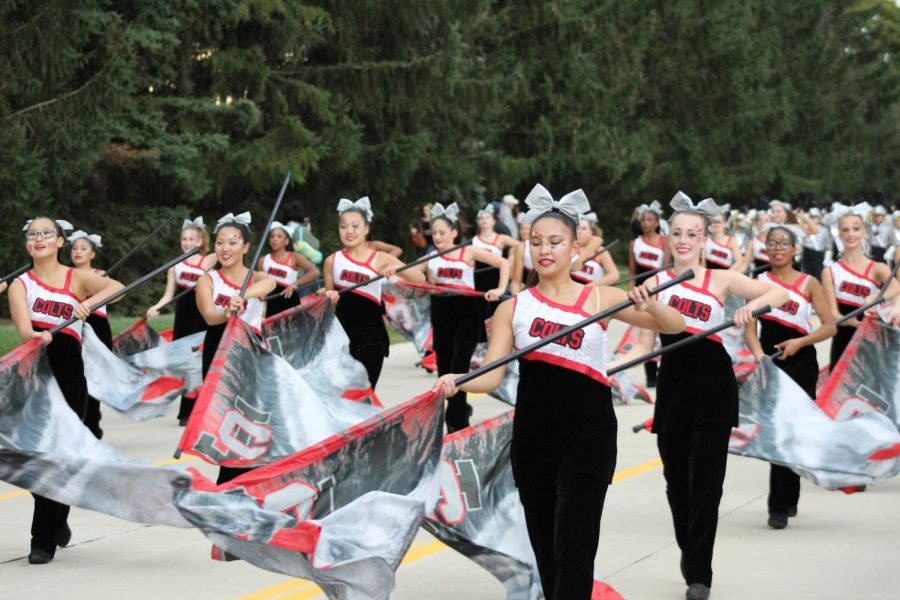 Senior Olivia Tu and the Color Guard march in front of the band.