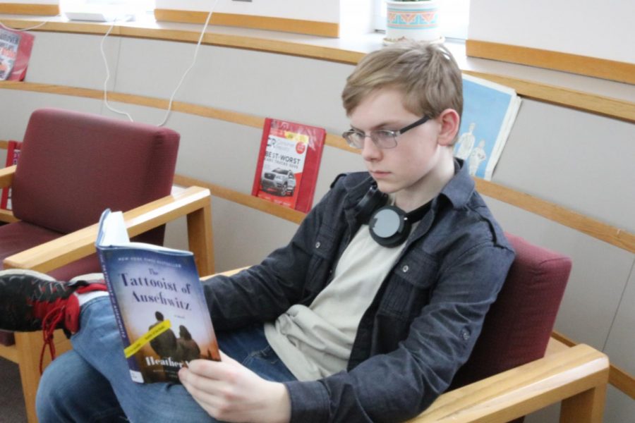 Freshman AJ Kowalak reads The Tattooist of Auschwitz in the media center.