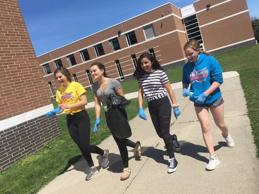 Juniors Jessica Geisler, Ellie Schmidt, Addie Schmidt and Izzy Meram collect a bag full of litter on campus.