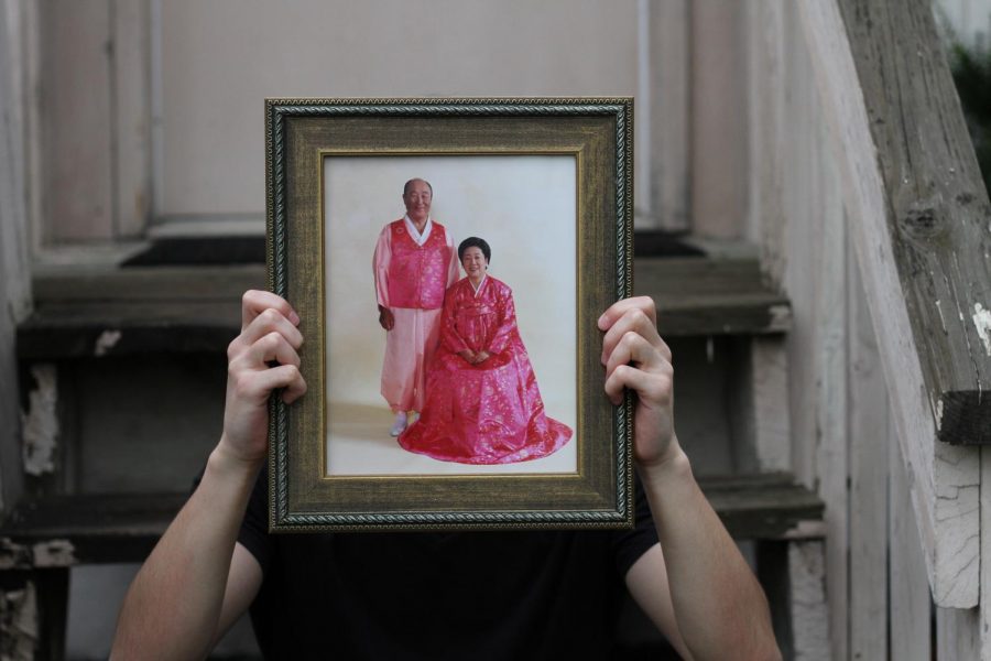 Senior Noah Smith holds up a photo of Sun Myung Moon, known by his followers as True Father, and his wife